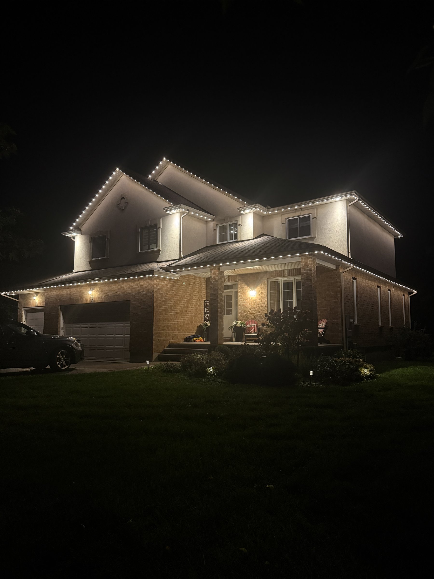 Warm white permanent lighting tracing a two-storey Ottawa-area home